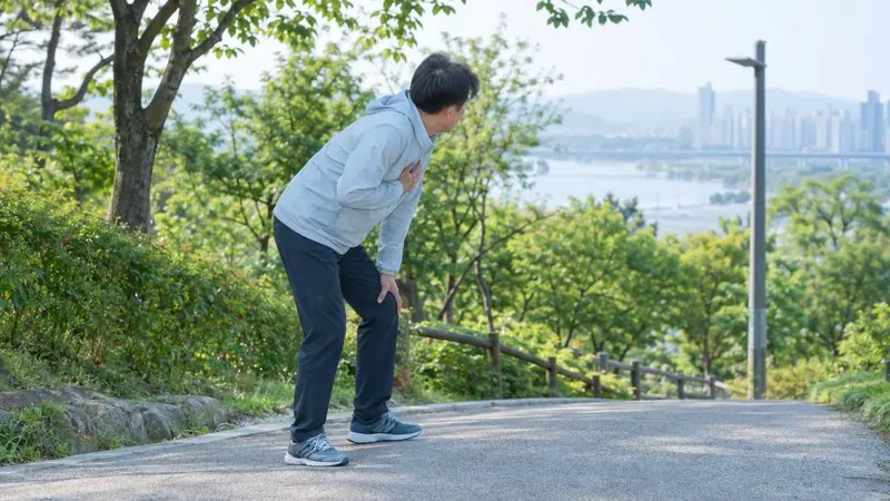 오르막길에서 가슴을 짚고 숨을 고르는 모습