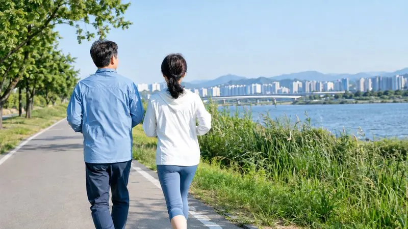공원에서 함께 빠르게 걷는 중년 부부